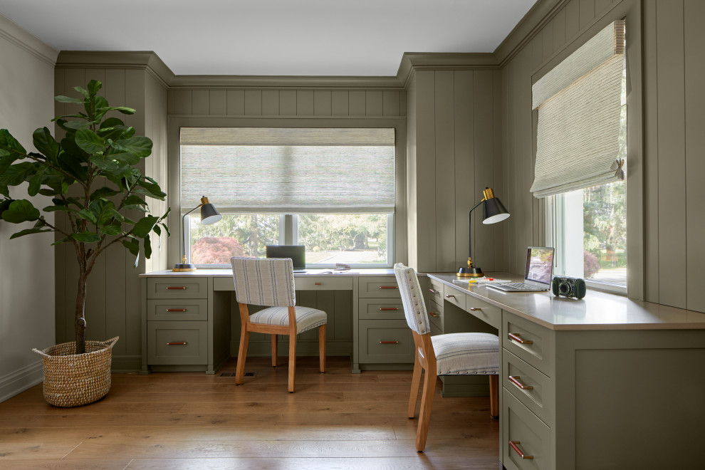 Exempel på ett lantligt arbetsrum, med gröna väggar, mellanmörkt trägolv, ett inbyggt skrivbord och brunt golv