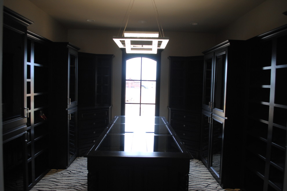This is an example of an expansive contemporary women's dressing room in Wichita with black cabinets.