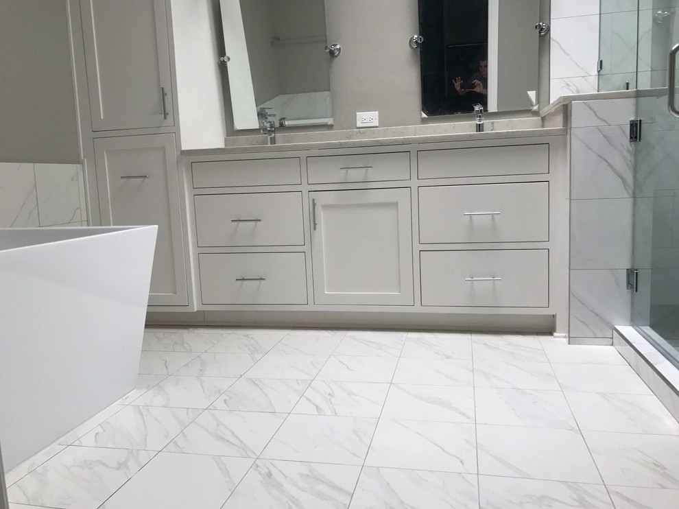 Design ideas for a large contemporary master bathroom in Dallas with shaker cabinets, white cabinets, a freestanding tub, a corner shower, white tile, porcelain tile, grey walls, porcelain floors, an undermount sink, quartzite benchtops, white floor and a hinged shower door.