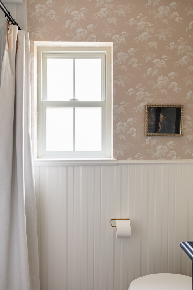This is an example of a small transitional 3/4 bathroom in Dallas with a one-piece toilet, pink walls and wallpaper.