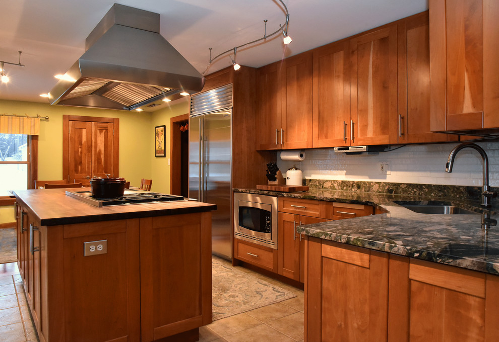 Example of a mid-sized single-wall porcelain tile kitchen design with an undermount sink, beaded inset cabinets, granite countertops, white backsplash, subway tile backsplash, stainless steel appliances and an island