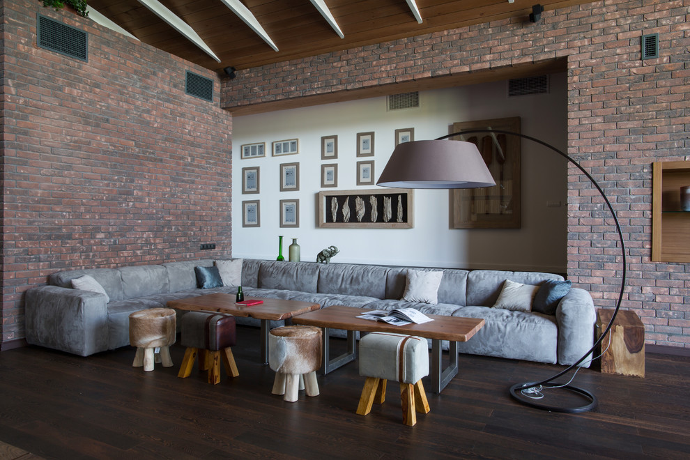 Inspiration for an expansive contemporary formal loft-style living room in Other with brown walls, laminate floors, a two-sided fireplace, a brick fireplace surround, a freestanding tv and brown floor.