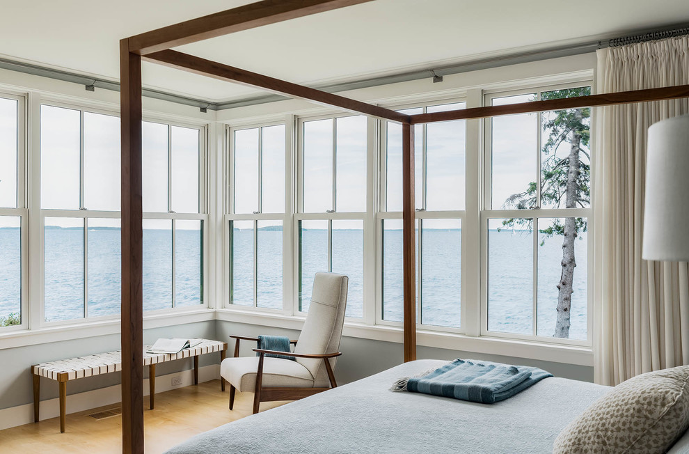 Inspiration for a large beach style master bedroom in Portland Maine with blue walls and light hardwood floors.