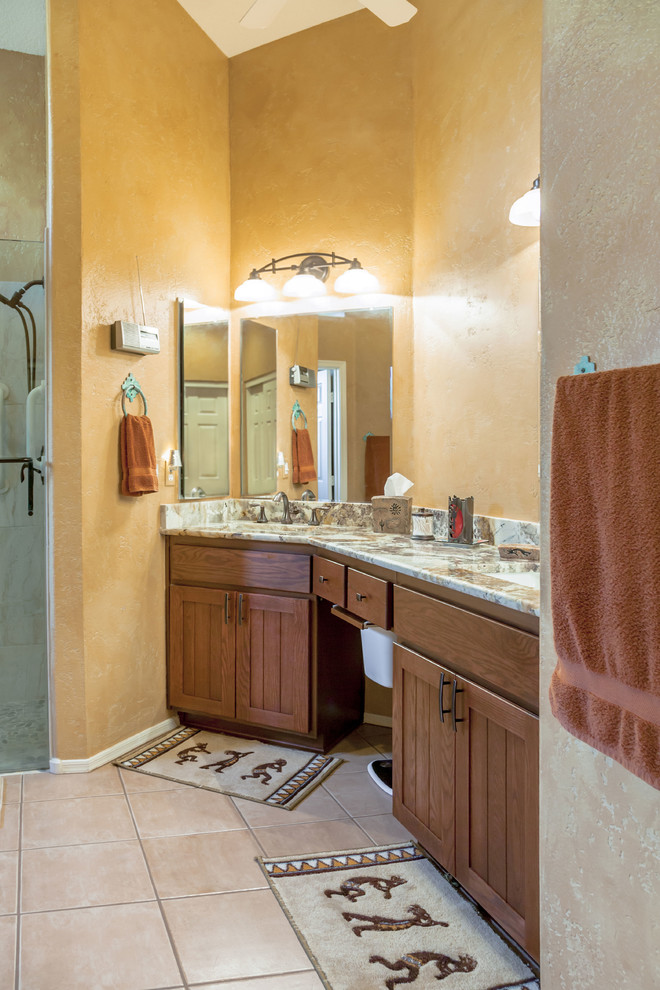 Master bathroom in Phoenix with beaded inset cabinets, medium wood cabinets, an alcove shower, a two-piece toilet, orange walls, ceramic floors, an undermount sink, granite benchtops, gray tile and pebble tile.