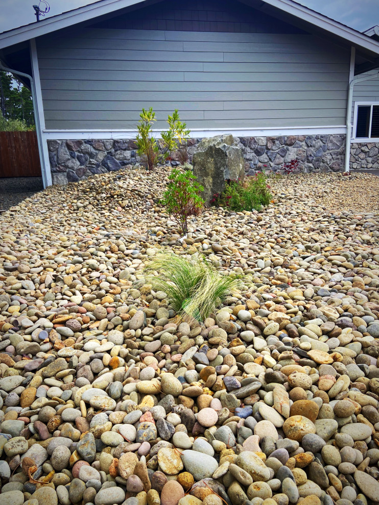Design ideas for a large beach style front yard full sun xeriscape in Portland with with rock feature and river rock.