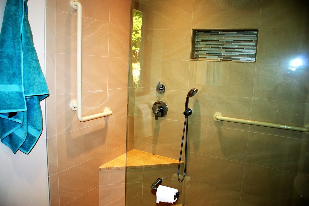 This is an example of a mid-sized contemporary 3/4 bathroom in DC Metro with flat-panel cabinets, light wood cabinets, an alcove shower, beige tile, brown tile, green tile, multi-coloured tile, matchstick tile, white walls, porcelain floors, an undermount sink, solid surface benchtops and a two-piece toilet.