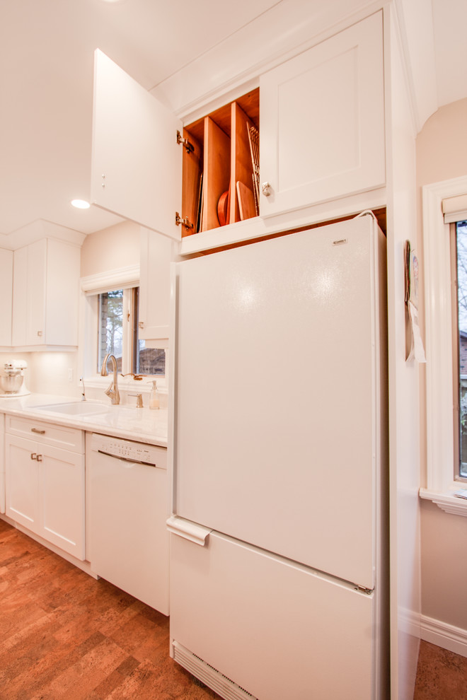 Photo of a transitional kitchen in Toronto with an undermount sink, recessed-panel cabinets, white cabinets, quartz benchtops, white splashback, ceramic splashback and white appliances.