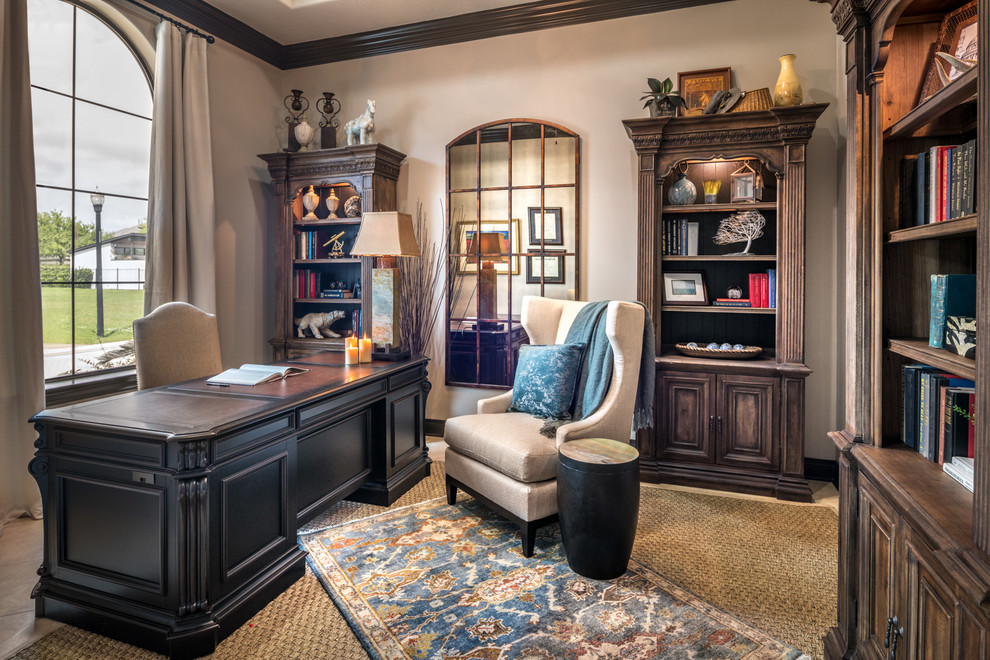 Mid-sized traditional home office in Houston with a library, beige walls, travertine floors, a freestanding desk and beige floor.