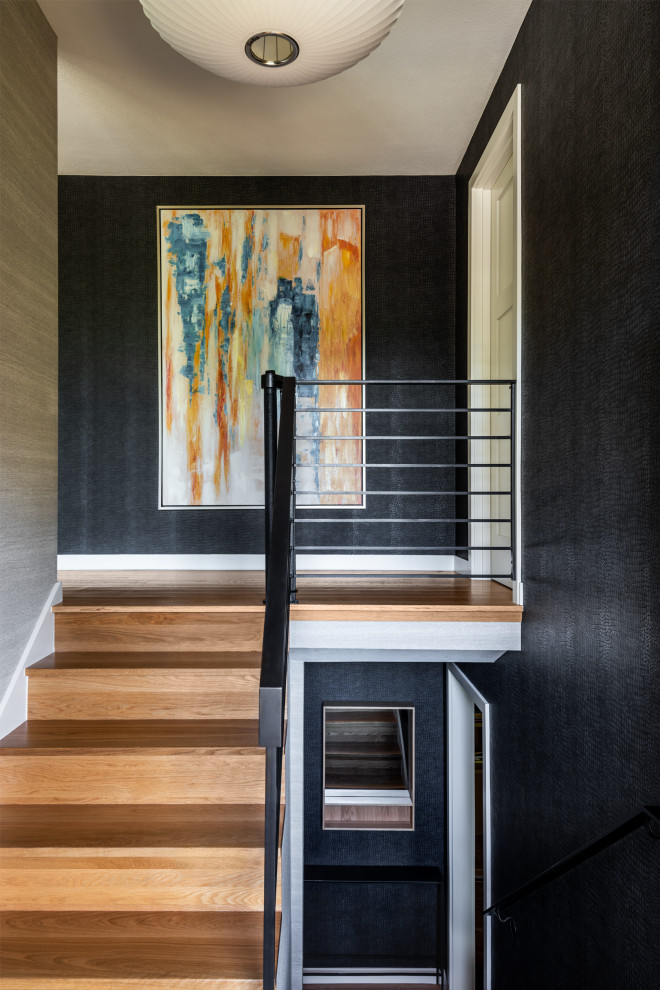 Small wood u-shaped staircase in Seattle with wood risers, metal railing and wallpaper.