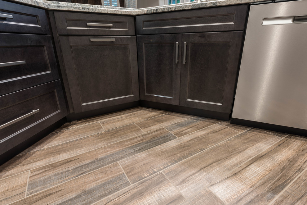 Inspiration for a large transitional l-shaped porcelain tile and brown floor eat-in kitchen remodel in Orlando with shaker cabinets, gray cabinets, granite countertops, multicolored backsplash, travertine backsplash, stainless steel appliances, a peninsula and multicolored countertops