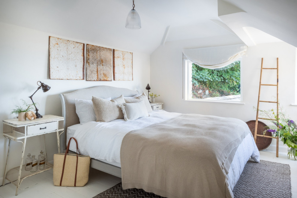 Example of a large beach style master painted wood floor and white floor bedroom design in Devon with white walls