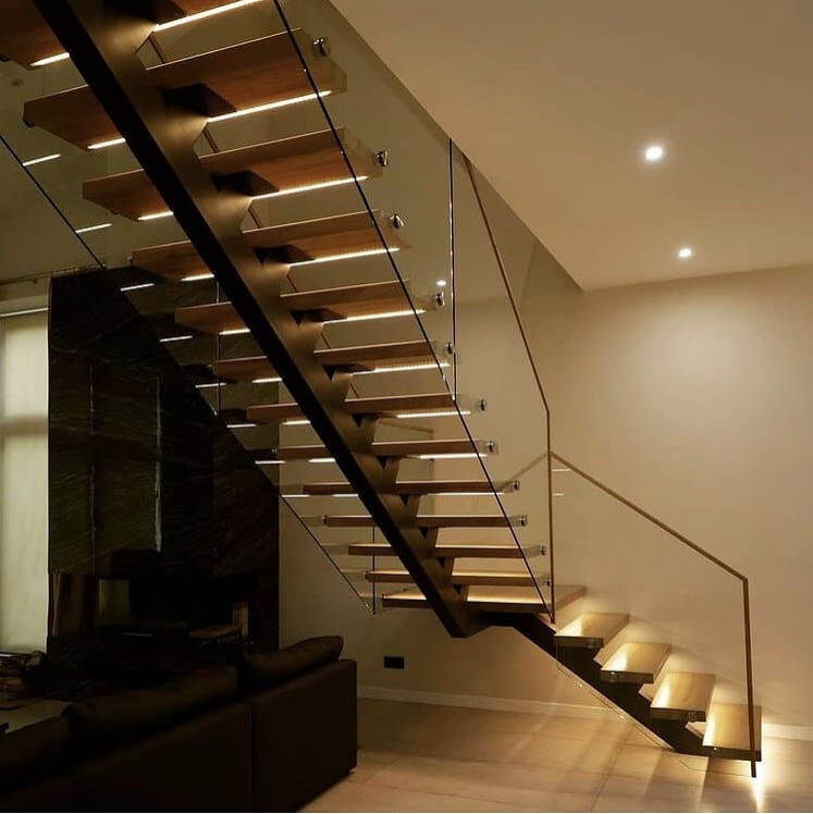 Пример оригинального дизайна: изогнутая деревянная лестница среднего размера в классическом стиле с деревянными ступенями и стеклянными перилами