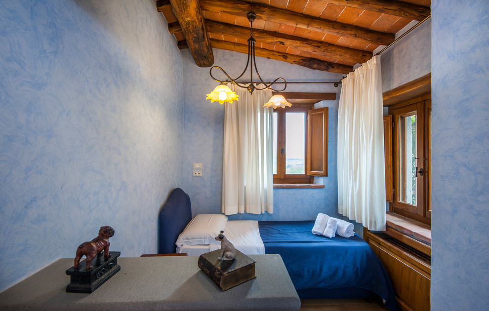 Design ideas for a country kids' bedroom for boys in Florence with blue walls and brown floor.