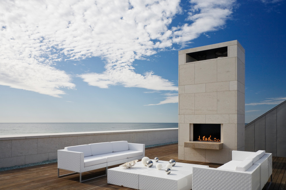Expansive coastal roof rooftop terrace in New York with a fireplace and no cover.