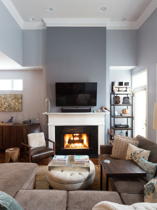 This is an example of a mid-sized transitional formal enclosed living room in Chicago with blue walls, medium hardwood floors, a standard fireplace, a concrete fireplace surround and a wall-mounted tv.