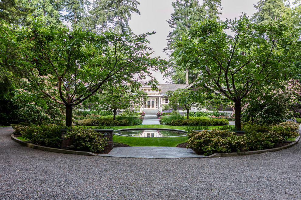 Photo of a traditional front yard driveway in Seattle with with pond and gravel.