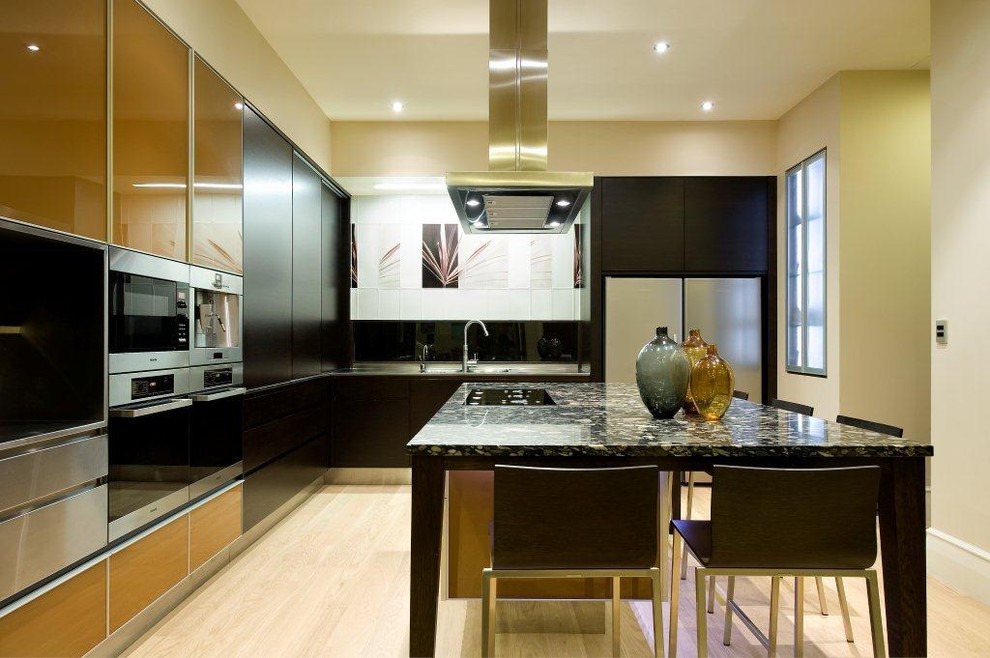 This is an example of a contemporary l-shaped kitchen pantry in Auckland with stainless steel appliances, flat-panel cabinets, dark wood cabinets, a double-bowl sink, granite benchtops, yellow splashback, porcelain splashback, light hardwood floors and with island.