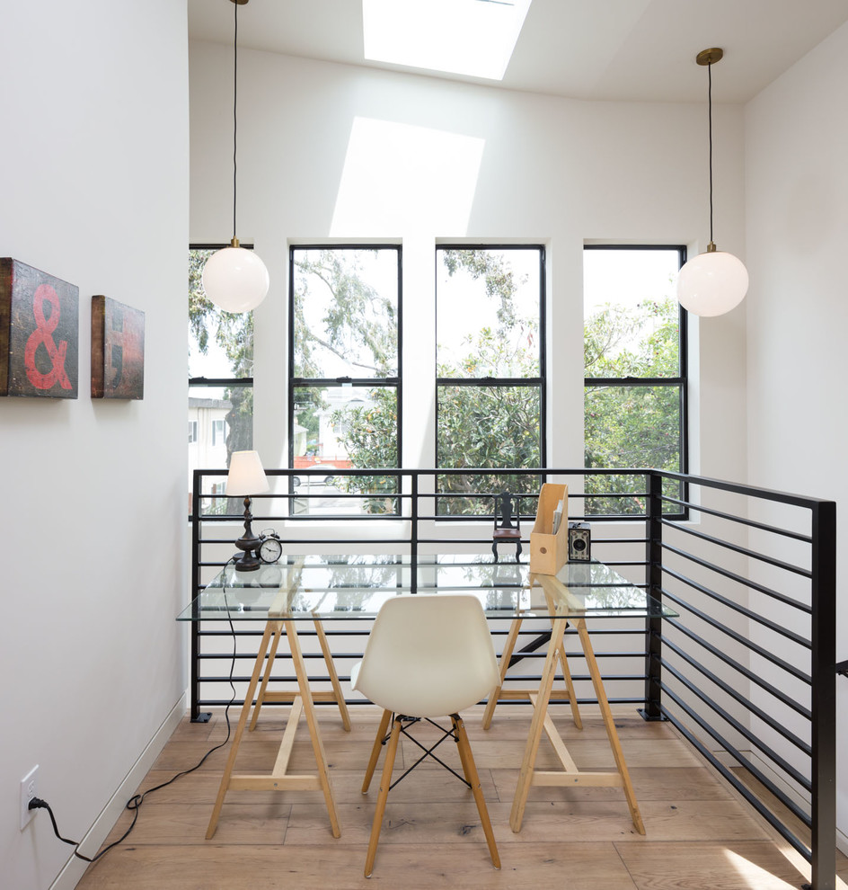Photo of a small contemporary study room in San Francisco with white walls, light hardwood floors, no fireplace and a freestanding desk.