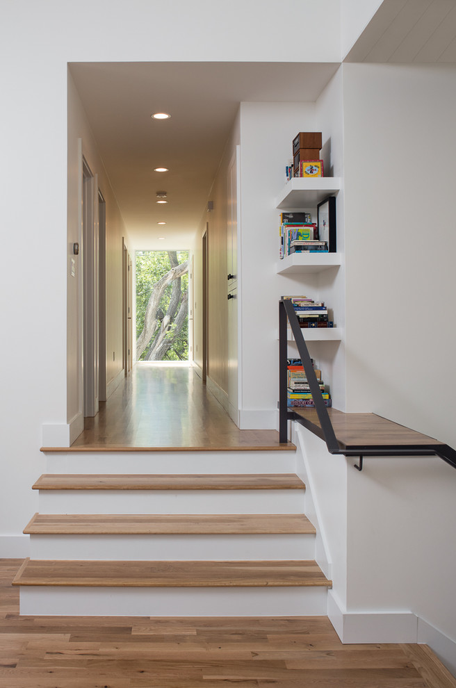 Design ideas for a small contemporary wood straight staircase in Austin with painted wood risers and metal railing.