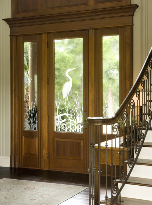 Large tropical front door in Charleston with beige walls, a single front door, a medium wood front door, dark hardwood floors and brown floor.