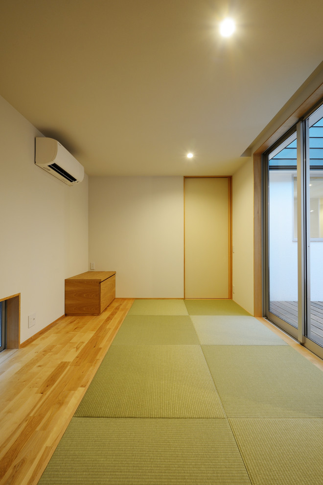 Cette image montre une salle de séjour nordique de taille moyenne et fermée avec un mur blanc, un sol de tatami, aucune cheminée, aucun téléviseur, un sol vert, un plafond en papier peint et du papier peint.