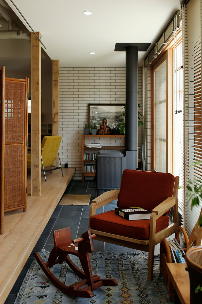 This is an example of an asian living room in Other with a wood stove and light hardwood floors.