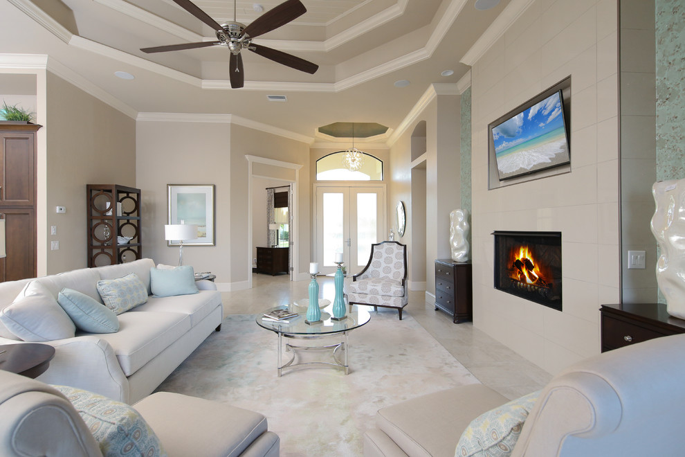 Inspiration for a large contemporary formal open concept living room in Miami with beige walls, ceramic floors, a standard fireplace, a tile fireplace surround, a wall-mounted tv and beige floor.
