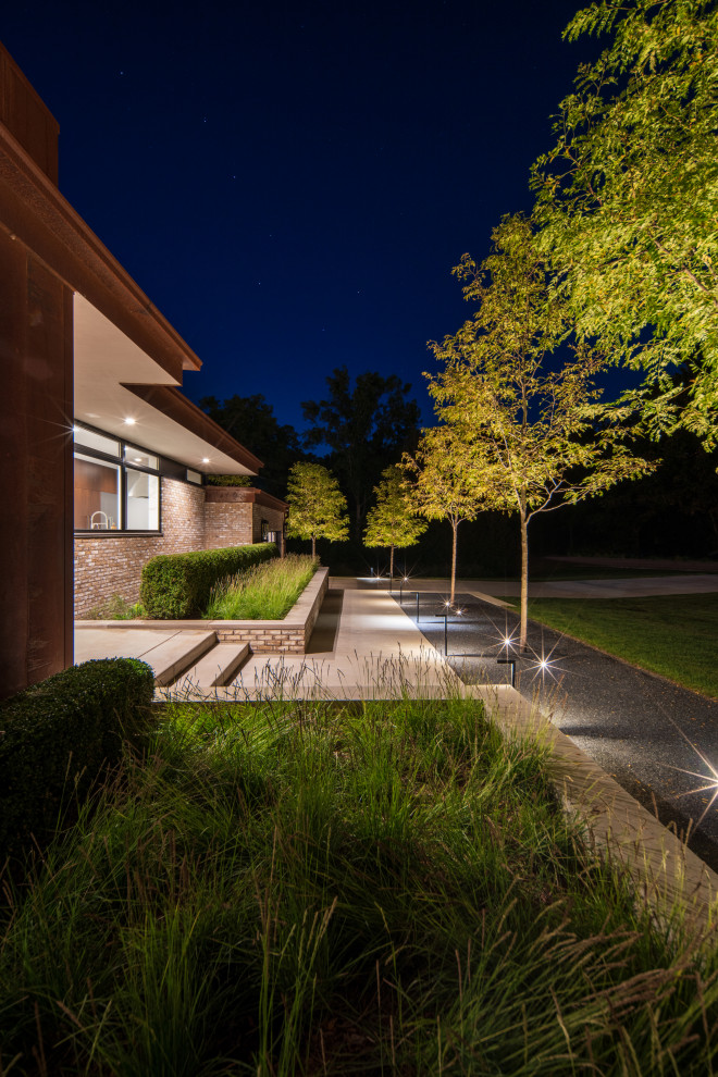 Стильный дизайн: большой участок и сад на переднем дворе в стиле модернизм с клумбами и покрытием из гранитной крошки - последний тренд