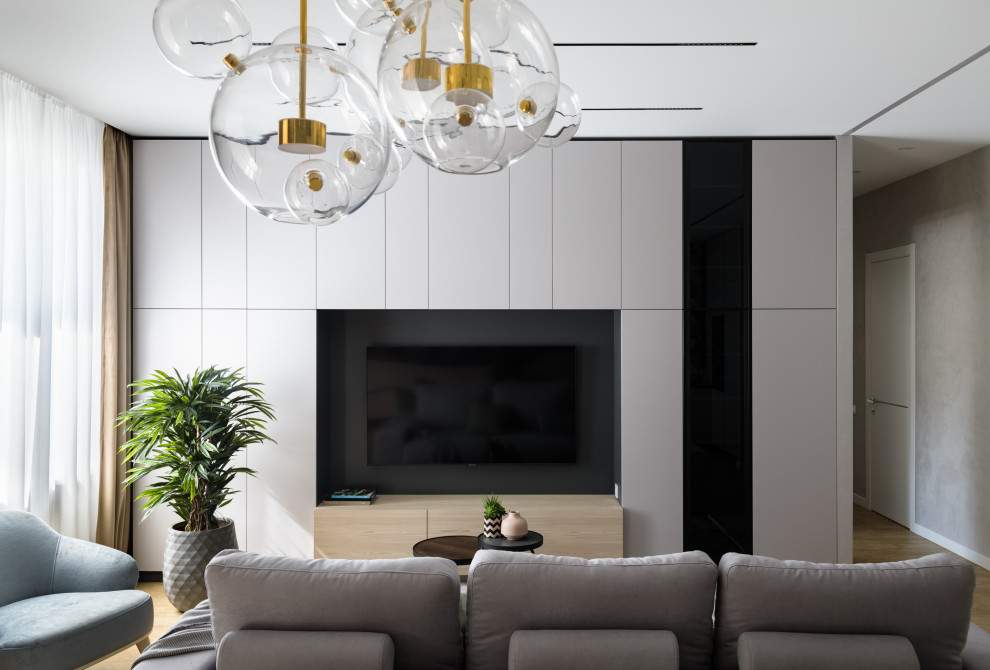 Стильный дизайн: открытая, объединенная, серо-белая гостиная комната среднего размера:: освещение в современном стиле с с книжными шкафами и полками, серыми стенами, пробковым полом и телевизором на стене - последний тренд