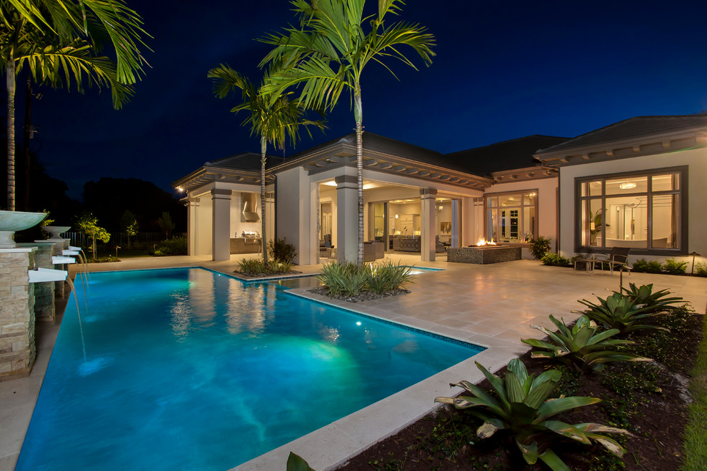 This is an example of a large contemporary backyard custom-shaped pool in Tampa with a water feature.