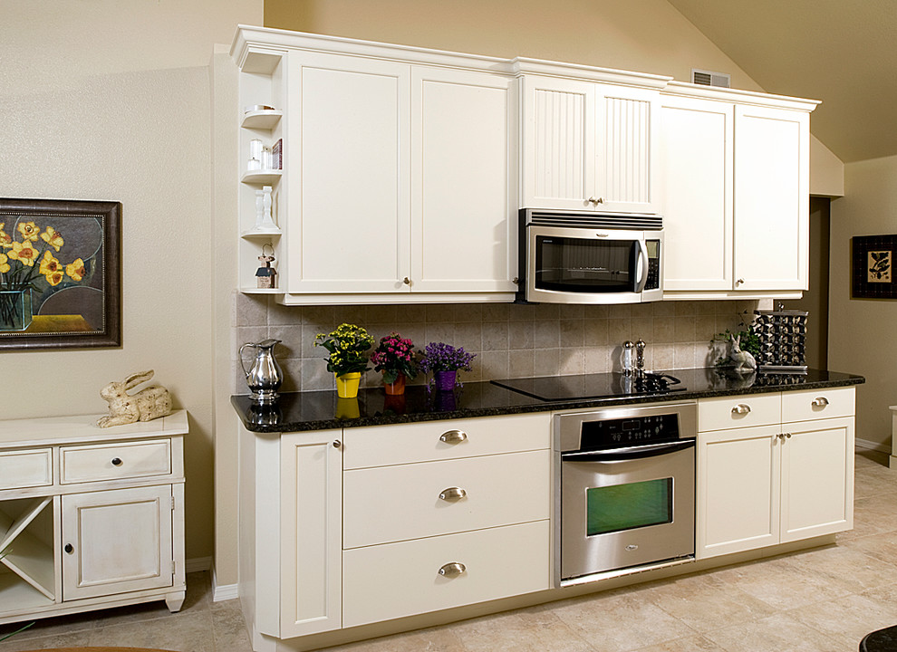 Eat-in kitchen - mid-sized coastal galley porcelain tile eat-in kitchen idea with an undermount sink, shaker cabinets, white cabinets, granite countertops, beige backsplash, porcelain backsplash, stainless steel appliances and yellow walls