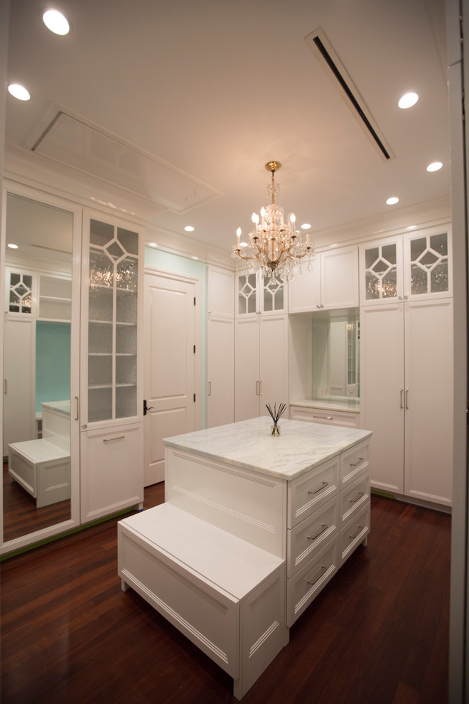 This is an example of a large traditional women's walk-in wardrobe in Tampa with shaker cabinets, white cabinets, medium hardwood floors and brown floor.