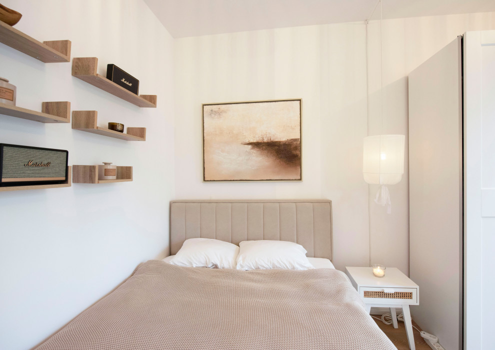 Modelo de salón abierto actual pequeño con paredes blancas, suelo de madera clara y suelo marrón