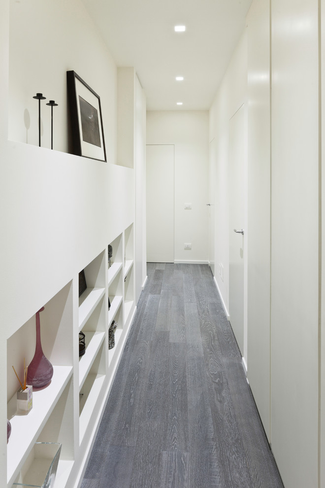 Photo of a contemporary hallway in Other with white walls, dark hardwood floors and grey floor.
