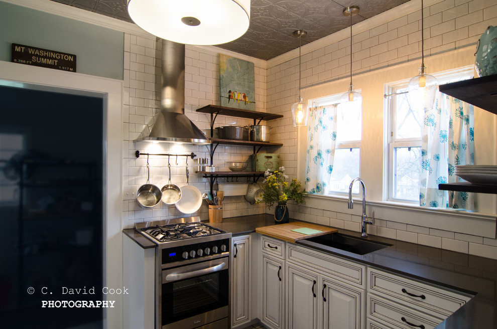 Enclosed kitchen - small transitional u-shaped ceramic tile enclosed kitchen idea with an undermount sink, raised-panel cabinets, white cabinets, solid surface countertops, white backsplash, subway tile backsplash, stainless steel appliances and no island