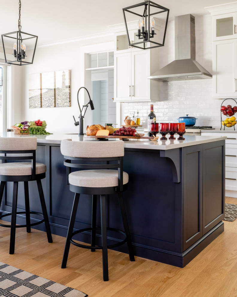 Inspiration for a transitional kitchen remodel in Providence with an undermount sink, shaker cabinets, quartzite countertops, subway tile backsplash and an island