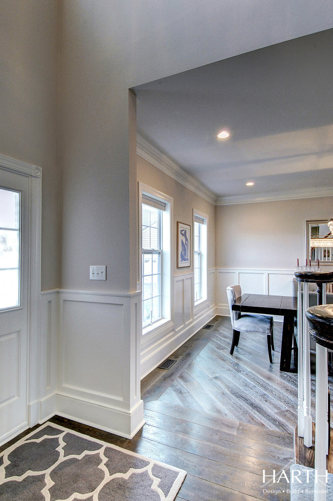 Photo of a mid-sized transitional foyer in Philadelphia with grey walls, dark hardwood floors, a single front door, a white front door, brown floor and decorative wall panelling.