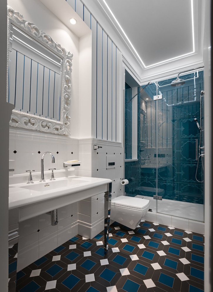 This is an example of a transitional 3/4 bathroom in Other with open cabinets, an alcove shower, a wall-mount toilet, blue tile, white tile, multi-coloured walls, a console sink, multi-coloured floor, a hinged shower door and white benchtops.
