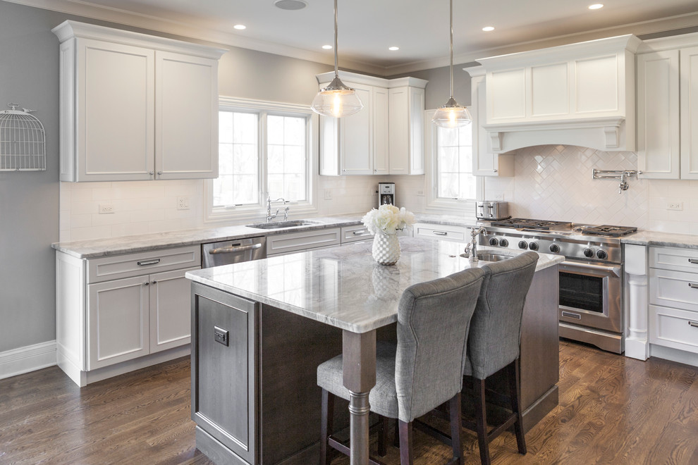 Mid-sized transitional l-shaped eat-in kitchen in Chicago with an undermount sink, beaded inset cabinets, white cabinets, marble benchtops, white splashback, subway tile splashback, dark hardwood floors, with island and brown floor.