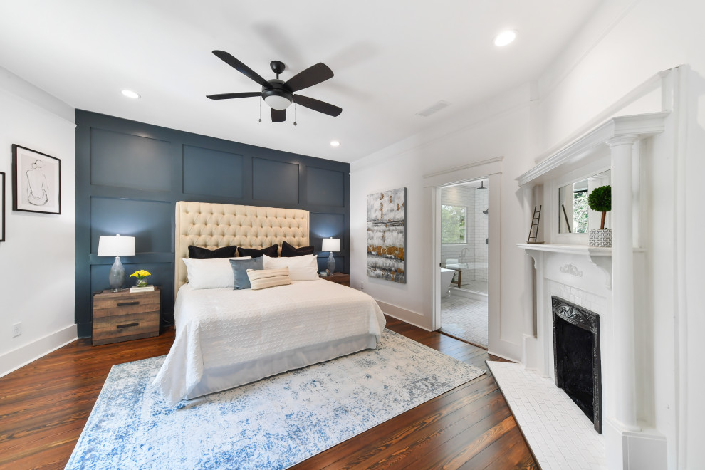 Design ideas for a mid-sized transitional master bedroom in Atlanta with multi-coloured walls, dark hardwood floors, a corner fireplace, a wood fireplace surround and brown floor.