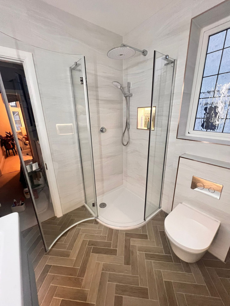 Свежая идея для дизайна: ванная комната среднего размера в стиле модернизм с угловым душем, инсталляцией, серой плиткой, серыми стенами, монолитной раковиной, коричневым полом, душем с распашными дверями, тумбой под одну раковину и подвесной тумбой - отличное фото интерьера