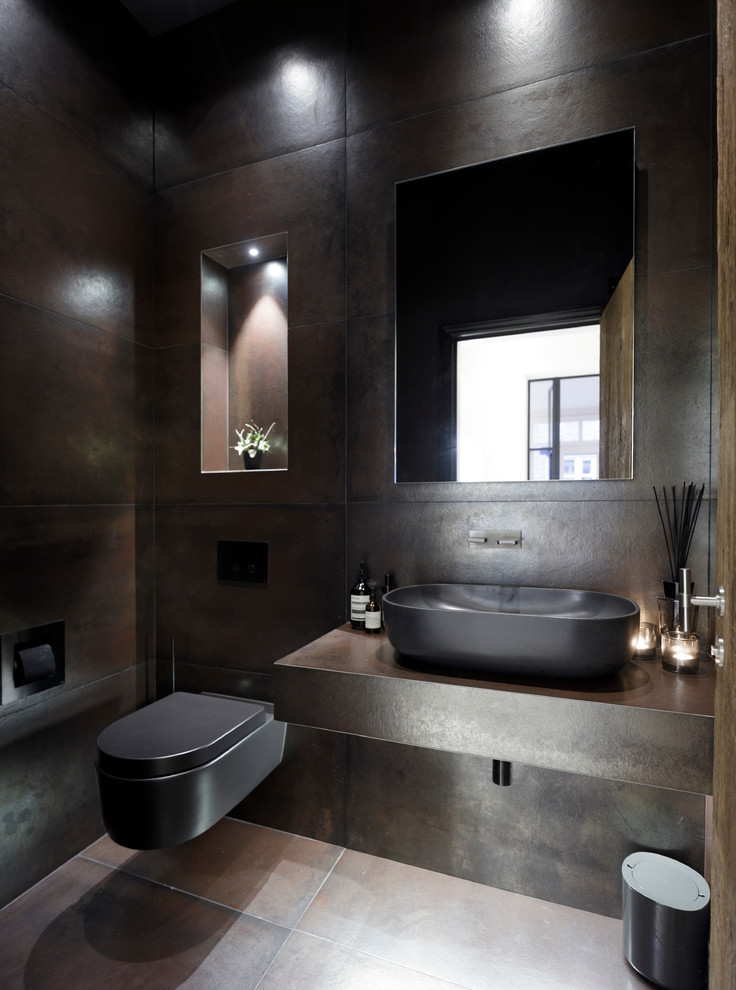 Small contemporary powder room in Cheshire with recessed-panel cabinets, dark wood cabinets, a wall-mount toilet, ceramic tile, ceramic floors, a trough sink and tile benchtops.