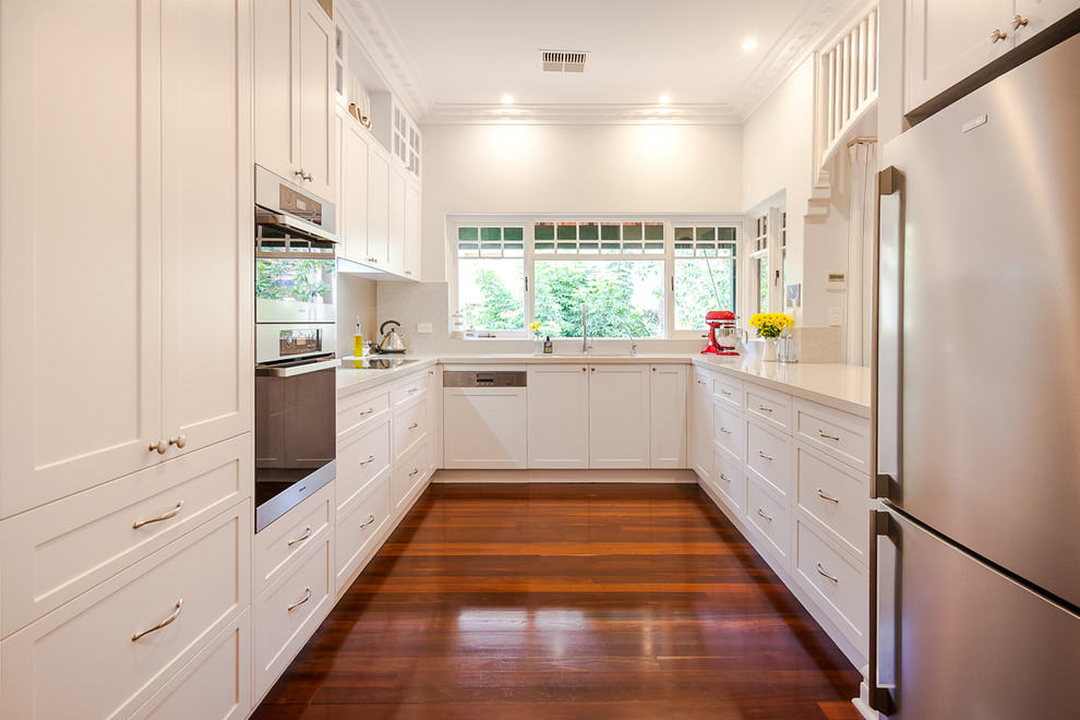 Photo of a traditional u-shaped eat-in kitchen in Perth with an undermount sink, recessed-panel cabinets, white cabinets, quartz benchtops and stainless steel appliances.