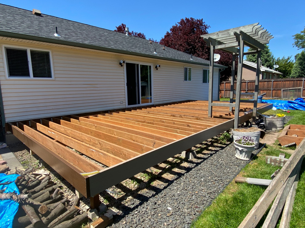 Example of a mid-sized arts and crafts backyard ground level deck design