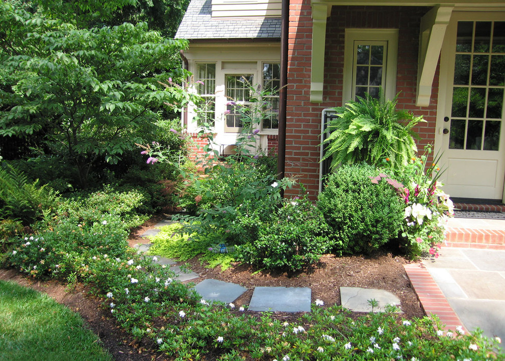 Design ideas for a mid-sized traditional side yard partial sun formal garden in Charlotte with a garden path and natural stone pavers.