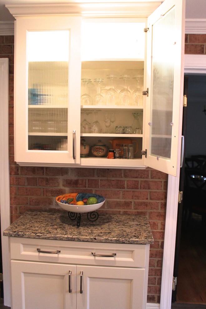Eat-in kitchen - mid-sized transitional u-shaped porcelain tile and brown floor eat-in kitchen idea in DC Metro with an undermount sink, recessed-panel cabinets, white cabinets, granite countertops, beige backsplash, porcelain backsplash, stainless steel appliances and an island