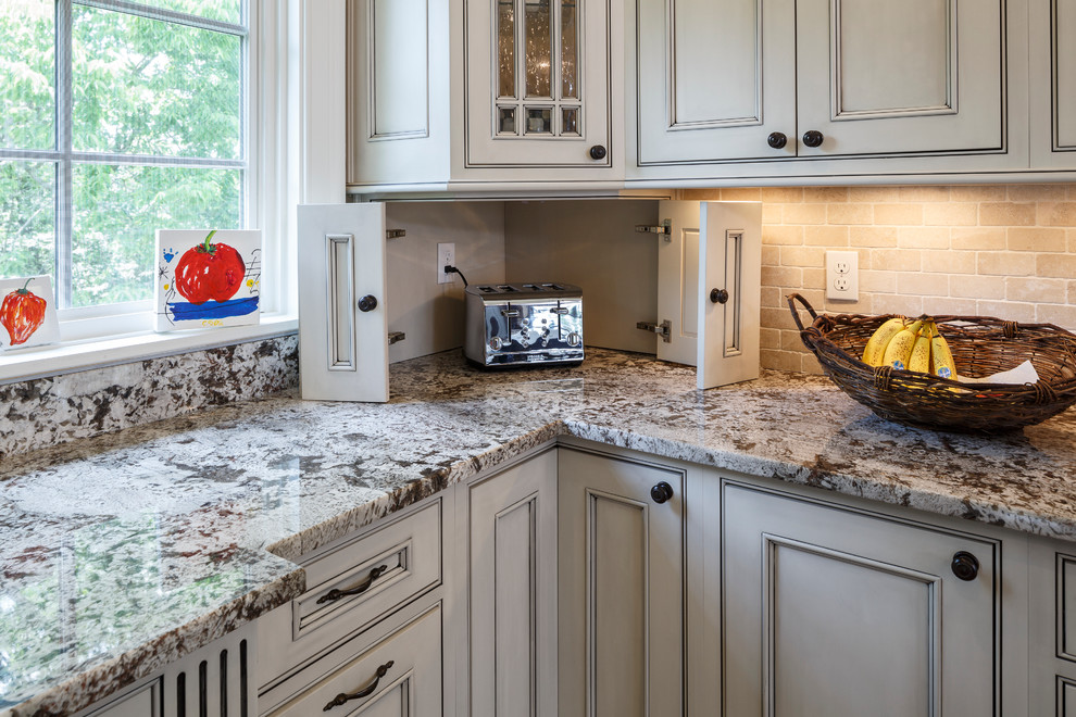 Inspiration for an expansive mediterranean u-shaped eat-in kitchen in Cincinnati with a double-bowl sink, flat-panel cabinets, distressed cabinets, marble benchtops, beige splashback, stone tile splashback, stainless steel appliances, medium hardwood floors and with island.