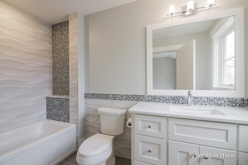 Design ideas for a mid-sized modern kids bathroom in Chicago with shaker cabinets, a one-piece toilet, ceramic tile, grey walls, ceramic floors, an undermount sink, pink benchtops, white cabinets, an alcove tub, a shower/bathtub combo, white tile, engineered quartz benchtops, grey floor and a shower curtain.