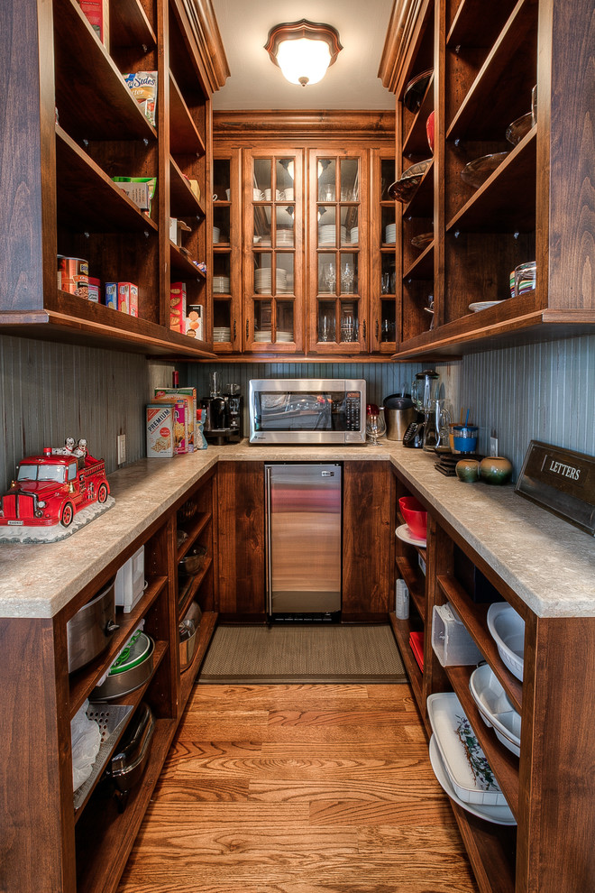 Traditional u-shaped kitchen pantry in Kansas City with open cabinets, dark wood cabinets, stainless steel appliances, medium hardwood floors and no island.