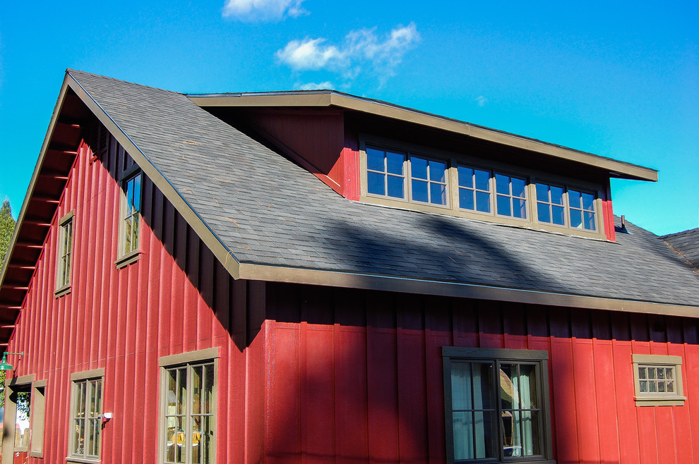 This is an example of a mid-sized country two-storey red exterior in San Francisco with wood siding and a gable roof.